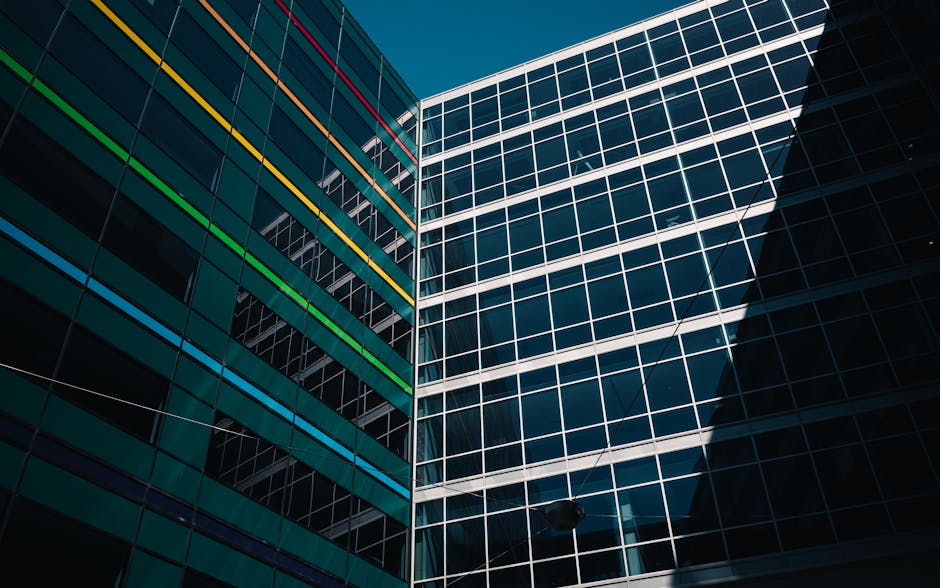 Architectural view of modern buildings with colorful stripes against a clear blue sky.