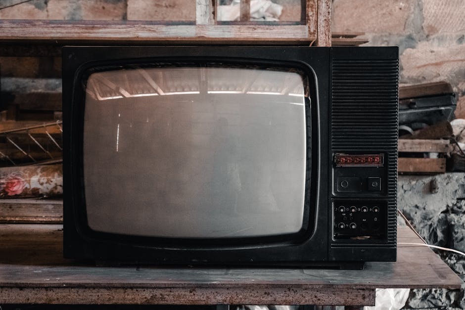 A classic black CRT television in a rustic, workshop environment with a nostalgic vibe.